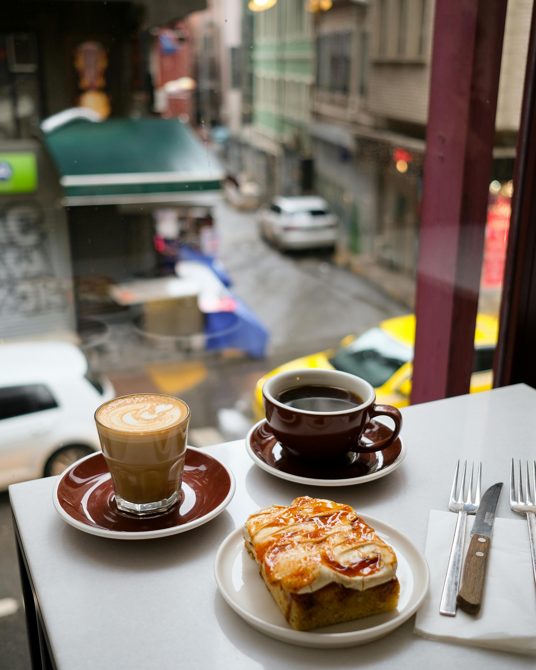 Café et viennoiserie dans un coffee shop de New York — vue sur la rue, ambiance locale